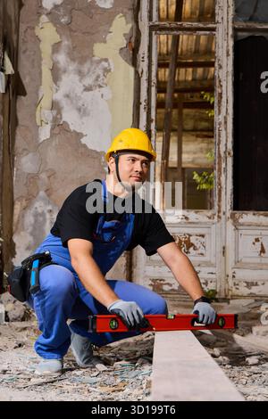 Worker measures leveled wood in a historic building renovation Stock Photo