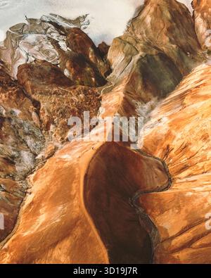 Aerial view of a river of rust carves through a vibrant green mangrove ...
