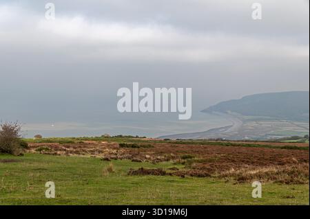 From the summit of West Porlock/ Porlock Hill off the A39 in the Exmoor National Pakr in southwest England, giving a misty wide panoramic view of Porl Stock Photo