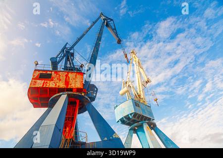 Two harbor cranes against a background of blue sky, bottom view Stock Photo