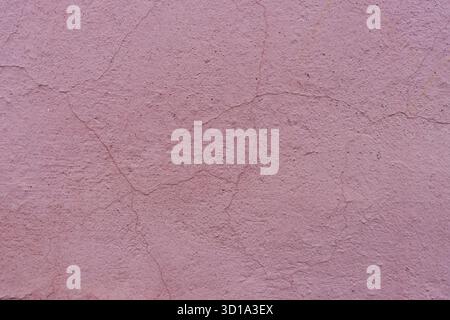 Pink weathered plaster with cracks. Abandoned concrete wall. Old plaster. Stock Photo