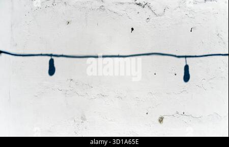shadow of lighbulb with cable on white grunge wall Stock Photo
