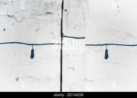 shadow of lighbulb with cable on white grunge wall Stock Photo