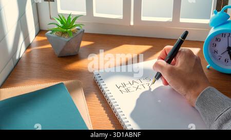 Notebook with the words “What’s Next?” written on a page. Planning, future decisions, career strategy, and goal setting concept. Stock Photo