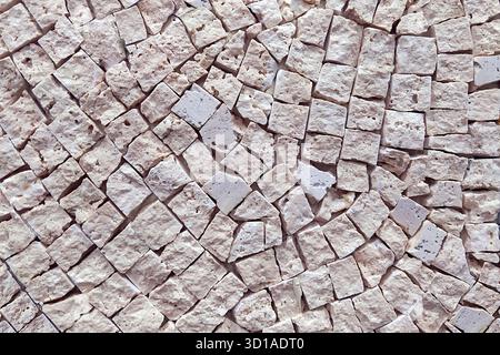 Large Roman mosaic background, textured mosaic of small squares, limestone or travertine. An interior design element or an abstract background. Stock Photo