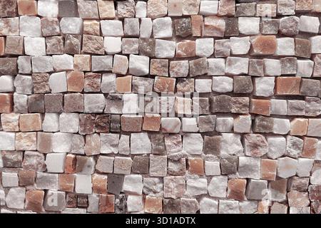 The background of the fragment is a Roman mosaic made of small cubic pieces of tesserae in soft beige, white and delicate pink shades. Background for Stock Photo