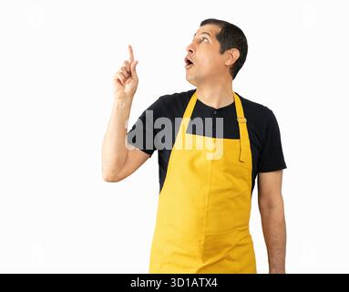 Man wearing employee apron over isolated background.Surprised pointing with finger to the side, open mouth amazed expression. Stock Photo