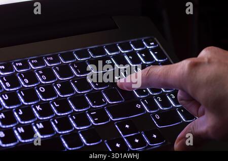 Finger presses the input key on the keyboard. Selected focus. Stock Photo