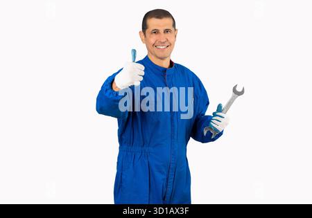 Mechanic posing with a wrench in his hand and gesturing thumbs up isolated on white background Stock Photo