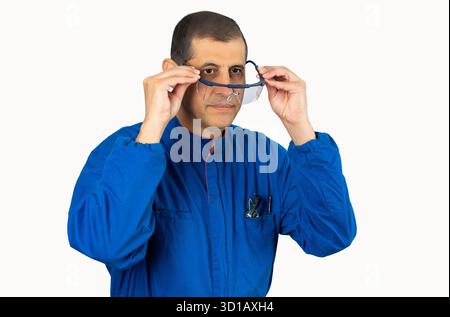 Mechanic worker putting protective glasses before work with white background. Stock Photo