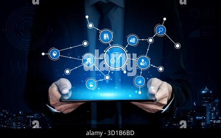 Professional businessman interacts with a digital tablet displaying various icons and connections representing technology, innovation, and modern busi Stock Photo