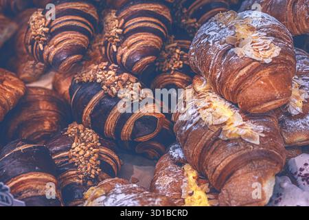 Fresh baked goods, chocolate and cream croissants on a supermarket display Stock Photo