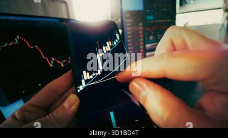 Cryptocurrency candlestick chart smartphone trading growth analysis. Hands zooming on bullish candlestick chart displayed on a mobile screen with fina Stock Photo