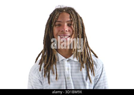 Young man with dreadlocks smiling, wearing a striped polo shirt on a white background Stock Photo