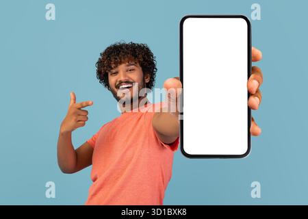 Cool Young Indian Guy Shows Empty Cell Phone Screen While Sharing Exciting Deal Stock Photo