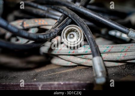 Close-up of industrial electrical cables with metal connector plug showing texture of braided insulation and wiring components used for machinery Stock Photo
