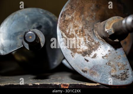 Close-up of worn metallic auger drill heads showing spiral blade texture, rust and mechanical wear used in soil drilling, construction foundation work Stock Photo
