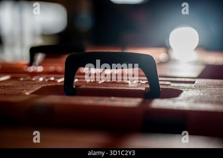 Black carrying handle on orange hard plastic toolbox representing industrial equipment storage, logistics safety, professional tool transport and dura Stock Photo