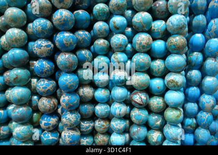 Blue sea sediment imperial jasper stone beads arranged in strands. Detailed full frame material texture for abstract graphic background concepts. Stock Photo