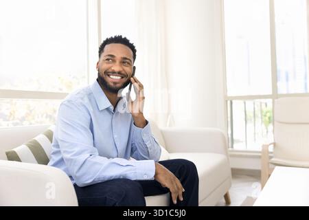 Young African man engaged in pleasant phone conversation Stock Photo