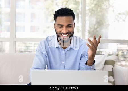 Handsome African man using laptop at home Stock Photo
