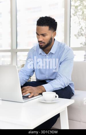 Serious African man using laptop with serious and focused expression Stock Photo