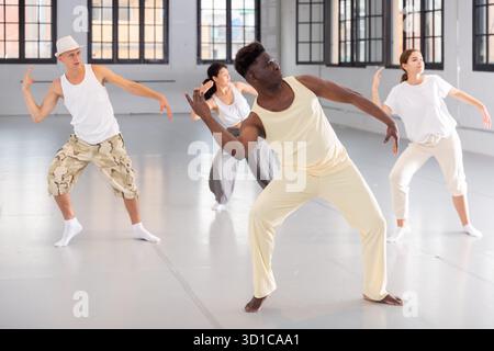 People practicing vigorous lindy hop movements in dance class Stock Photo