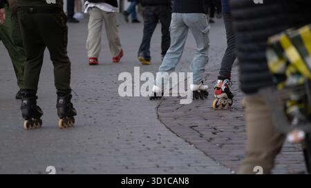 Group of people rollerblading together on a cobblestone street in the city. The image captures an active lifestyle, teamwork, and outdoor recreation i Stock Photo