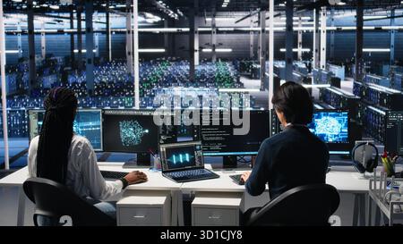 Delighted team in data center celebrating finishing neural network software development. Ecstatic coworkers doing high five in server room after successfully implementing machine learning, camera A Stock Photo
