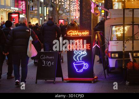 Cologne, Germany December 4 2024: Neon sign for Glühwein and Hot Chocolate on a street food trike, capturing the bustling atmosphere of Cologne's Schi Stock Photo