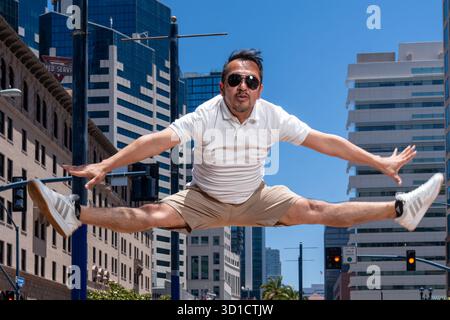 A male dancer from Todos performs dynamic jumps and expressive movements in the streets of the city on a sunny day. Captured on June 15 2025 in San Di Stock Photo