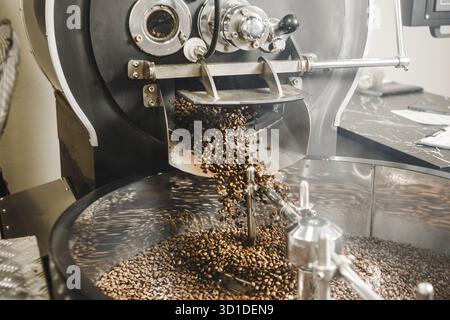 Freshly Roasted Coffee Beans Pouring From the Roaster Into the Cooling Tray in Roasting Facility Stock Photo