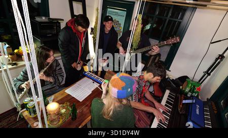 PRODUCTION - 23 October 2025, Lower Saxony, Osnabrück: Music student Vincent Jeremies (r), who lives in the smallest student hall of residence in Germany, practices with other students and plays the piano. It was a dream come true for him when he was given a place to live in the dormitory, which measures just 19 square meters. The mini house stands on the foundation walls of a former fortified tower from the 12th century and is centrally located in Osnabrück's city center. Photo: Jörn Hüneke/dpa Stock Photo