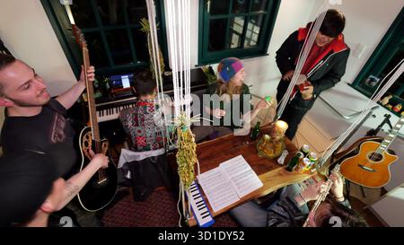 PRODUCTION - 23 October 2025, Lower Saxony, Osnabrück: Music student Vincent Jeremies (2nd from left), who lives in the smallest student hall of residence in Germany, practices with other students and plays the piano. It was a dream come true for him when he was given a place to live in the dormitory, which measures just 19 square meters. The mini house stands on the foundation walls of a former fortified tower from the 12th century and is centrally located in Osnabrück's city center. Photo: Jörn Hüneke/dpa Stock Photo