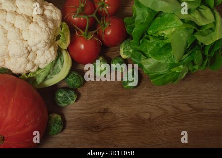 Autumn vegetable medley: pumpkin, cauliflower, tomatoes, and brussel sprouts on wood Stock Photo
