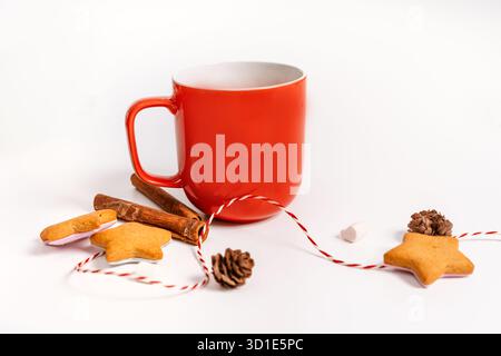 A red mug with cocoa and cookies and objects celebrating Christmas and new year on an isolated background, a place for text Stock Photo