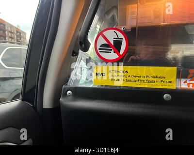 Warning sign in a New York taxi cab 'Assaulting a driver is punishable by up to twenty-five years in prison' and no fast foods allowed. Stock Photo