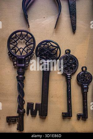 Milan, Italy, Europe: ancient iron keys forged in wrought iron leaned on a raw linen cloth, ancient crafts, blacksmith Stock Photo