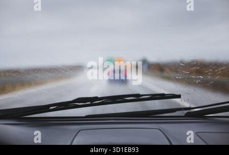 Car driving in rainy bad weather windshield drops water on road Stock Photo
