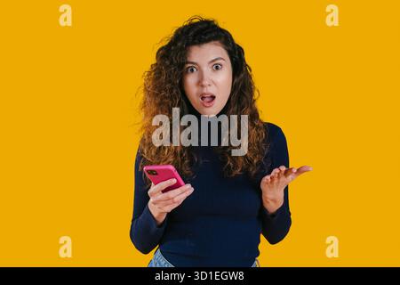 Brightly expressive woman shows surprise while using her mobile Stock Photo