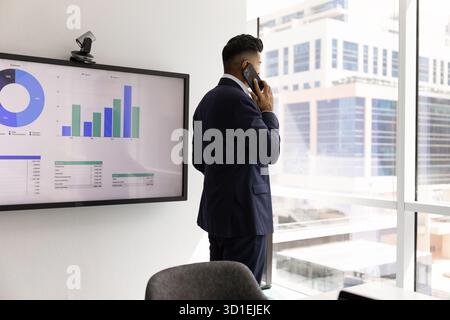 Thoughtful serious Indian businessman talking on mobile phone Stock Photo