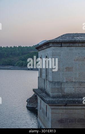 Reservoir on a windy day with small waves breaking against the retaining wall, creating ephemeral white foam Stock Photo