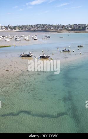 Over the shallow, turquoise water and moist sandy soil at low tide (low tide), with the shadows of currents and rocks visible in the water and numerou Stock Photo
