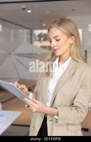 Focused busy young executive woman typing on digital tablet pc Stock Photo