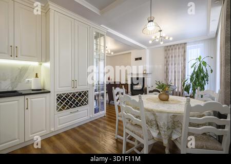 Modern classic large white colored luxurious kitchen and dining room in studio apartment interior Stock Photo