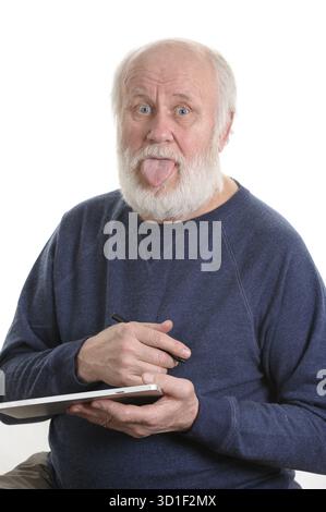 Funny bald and bearded senior man with tongue sticking out using tablet computer, isolated on white Stock Photo