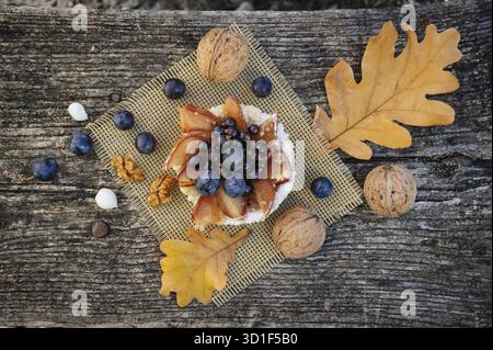 Romantic autumn still life with basket cake, walnuts, blackthorn berries and leaves, top view Stock Photo