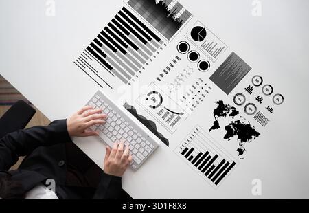 A woman is engaged in analyzing detailed black and white data visualizations on her desk. The arrangement includes charts, graphs, and a world map Stock Photo