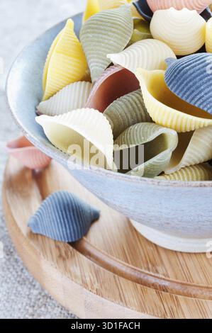 Pasta in bowl on a wooden board close up Stock Photo