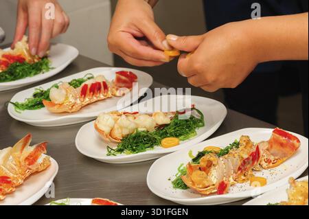 Serving and decorating of prepared lobsters on plates Stock Photo